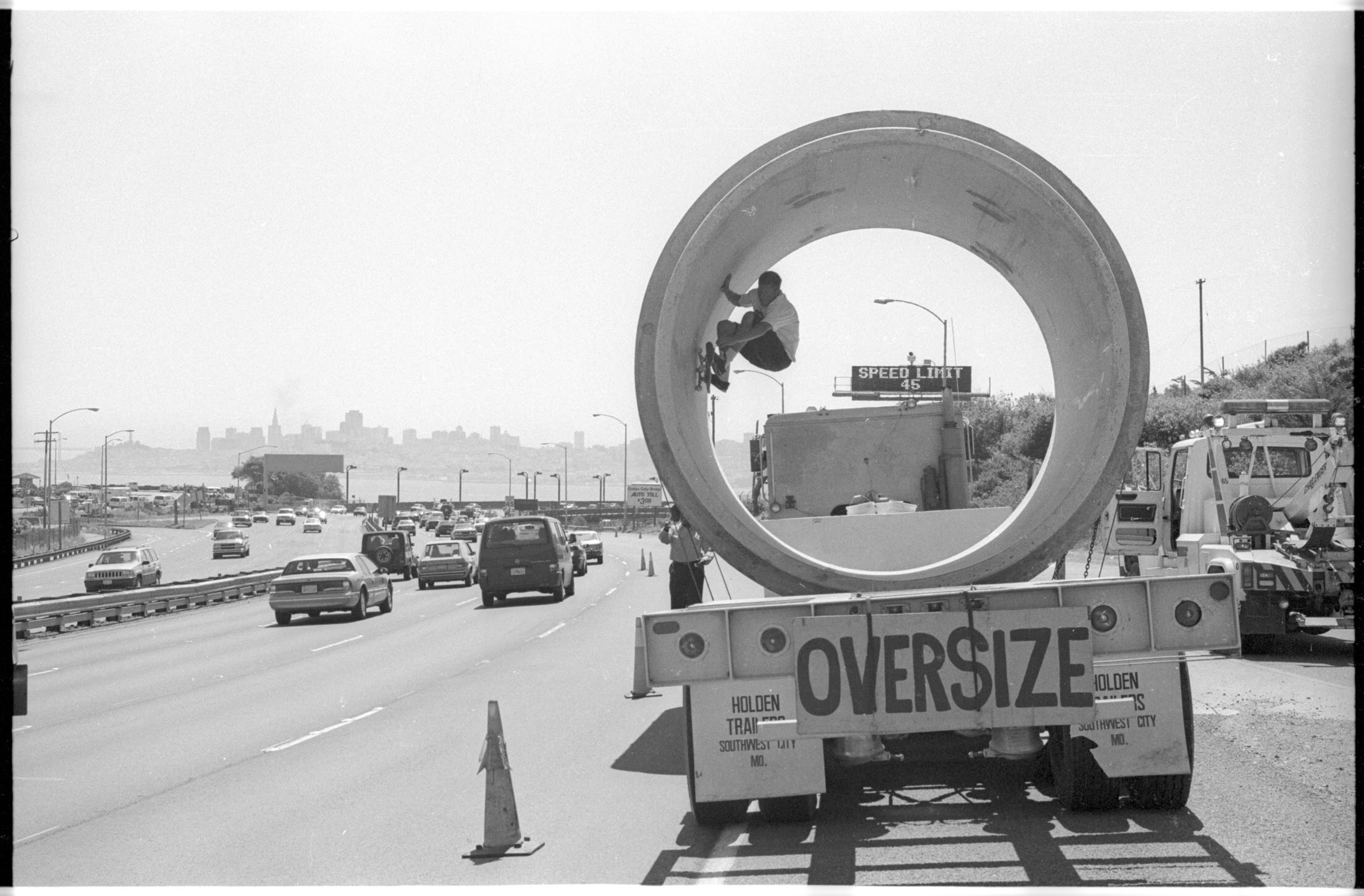 Morgan skating through a large concrete pipe beside a California freeway