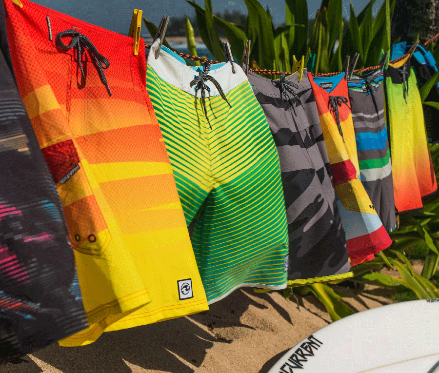 Colorful boardshorts hanging outdoors