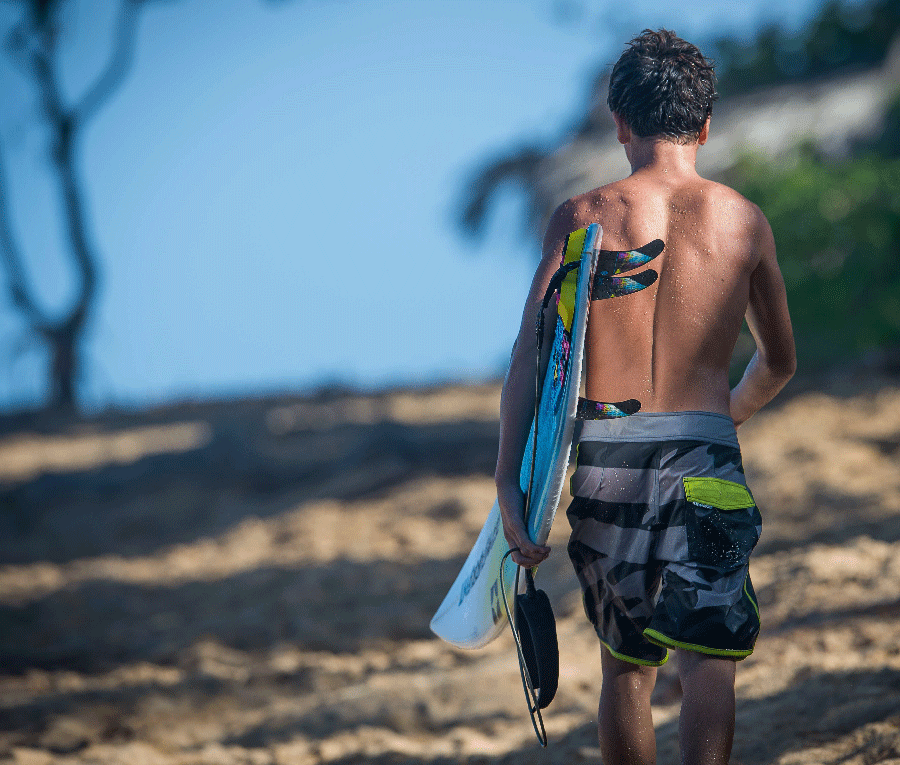 Surfer walking away carrying a board